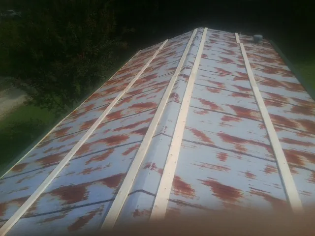 Rusted metal roof panels with new wood purlins before replacement — Storm Damage Roof Repair in Rolling Meadows by Roofing Brothers