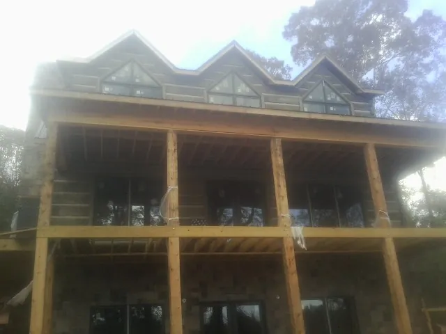 Dormers and porch framing on a large log home under construction — Roof Coating work by our crew in Rolling Meadows