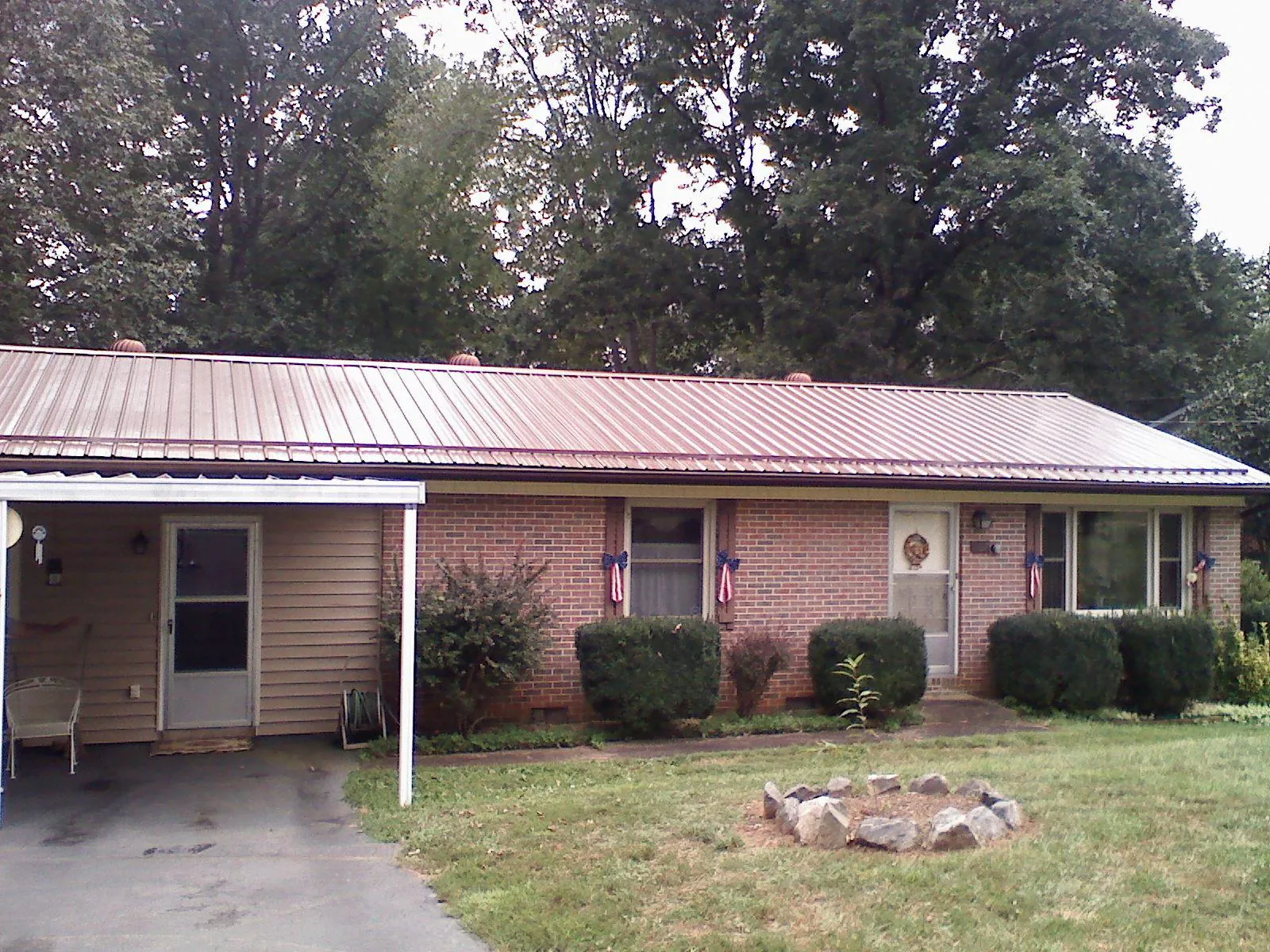 Bronze metal roof and carport on a brick ranch home — Roof Repair work by our crew in Rolling Meadows